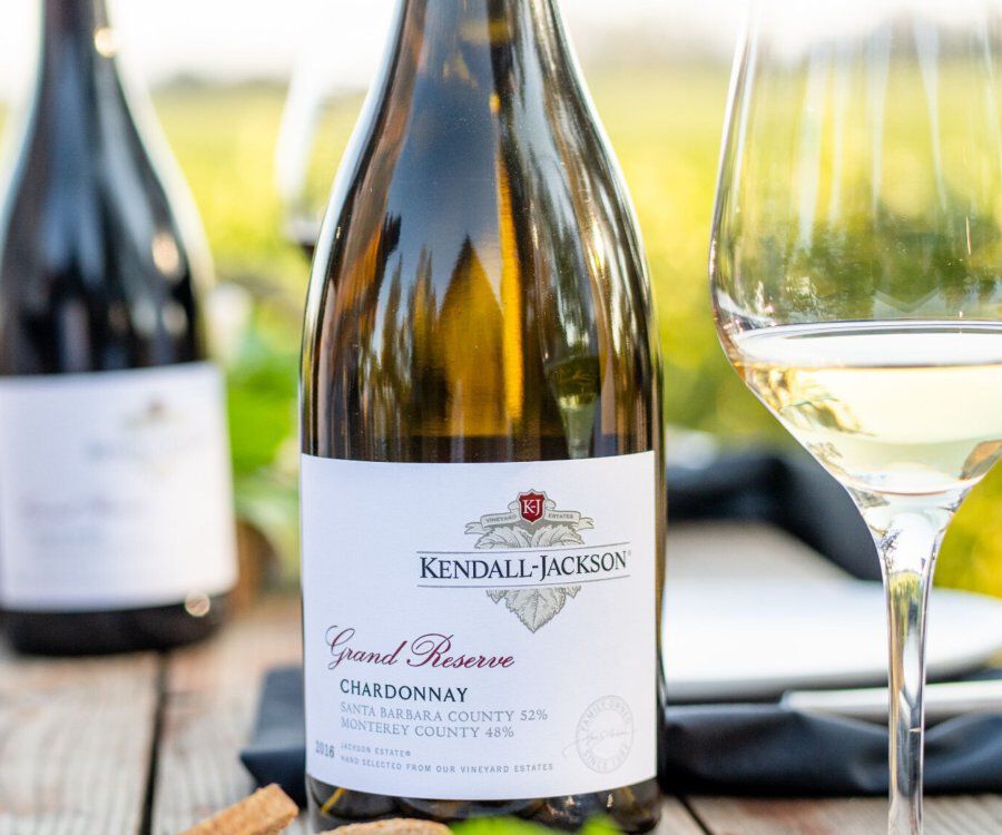 Close up of a bottle of Kendall-Jackson Chardonnay next to a glass of wine. 